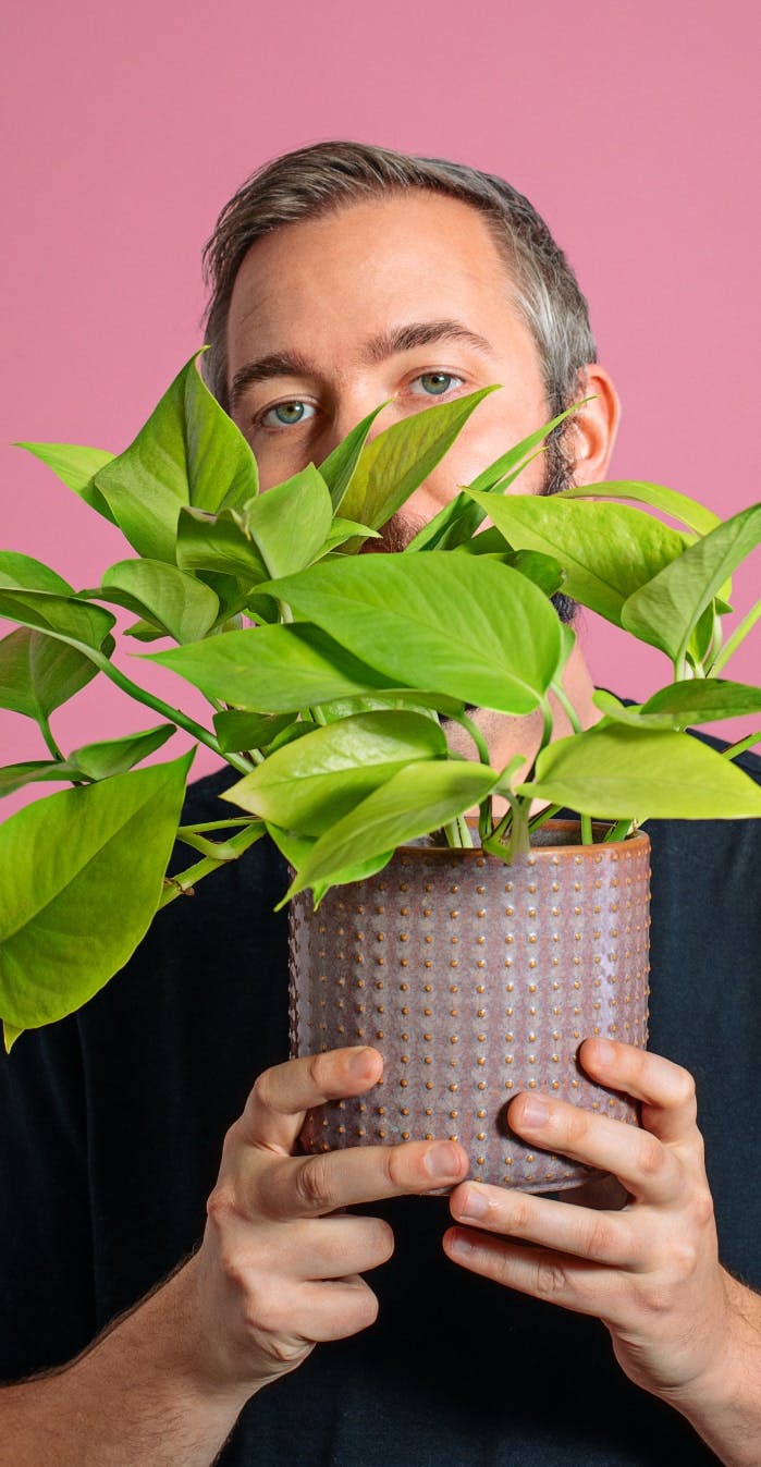 Man Holding Plant In Face
